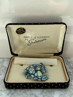 Open presentation box showing brooch and Sherman branding