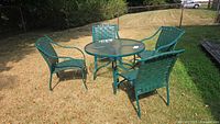 Full view of glass-top table and four chairs on lawn