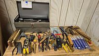 Overall lot with toolbox open and tools spread on table