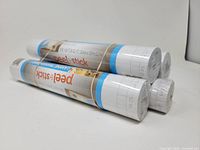 Four sealed rolls of Duck peel & stick shelf liner bundled together