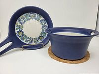 Blue Figgjo skillet with floral interior and matching blue open casserole on coaster