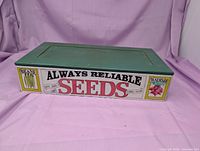 Closed green wooden seed box showing Always Reliable Seeds graphics on front