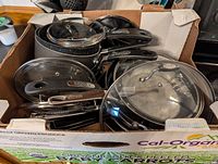 Box containing assorted pans and lids