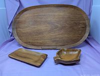 All three teak pieces displayed: large oval tray, small rectangular tray, leaf dish