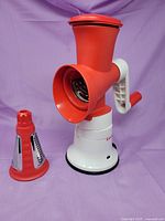 Grater assembled on base with one cone beside it