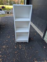 Front view of white bookcase showing three shelves