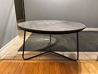 Front view showing full coffee table with stone top and iron tripod legs