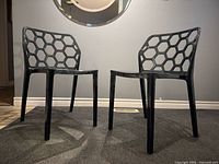 Both smoked lucite honeycomb chairs side by side angled