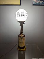 Lamp illuminated showing BAR globe shade on Seagram's V.O. bottle