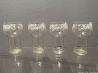 Four clear glass Pepsi-Cola tumblers showing shape and logo