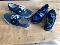 Both pairs of shoes side by side on floor