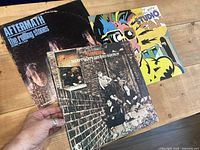 All three album covers fanned out on table