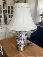 Full view of lamp with shade on wooden table