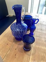 Group of four cobalt blue glass items on table