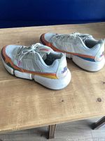 Side view of both sneakers showing uppers, colours and midsoles