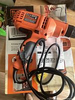 Full view of Black+Decker DR260 corded drill/driver coiled on top of its original box