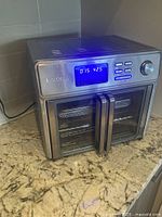 Front view of Kalorik MAXX air fryer oven, powered on