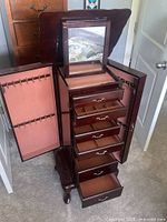 Armoire open showing mirror, side doors, drawers