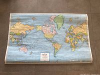 Full view of rolled-out world map showing complete layout and metal edge