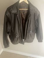 Full front view of leather bomber jacket on hanger