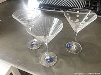 All three Mikasa martini glasses showing distinct patterns and stickers on bases