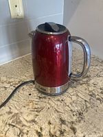 Full view of red Oster electric kettle on countertop