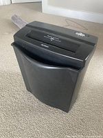 Full view of black paper shredder showing bin and top feed slot