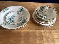 Full lot showing serving bowl, dessert bowl, stack of plates and teacups