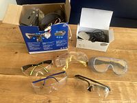 Lot overview showing all items: five safety glasses, motion light in box, Phonak TVLink II basestation box with contents