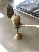 Full view of brass oil lamp showing reflector, font, wick arm and pedestal base