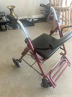 Side angle of rollator showing seat, basket, frame and wheels
