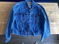Front view of Levi's denim jacket laid flat showing overall condition and design