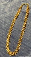 Full view of gold-tone Christian Dior chain necklace on fabric background
