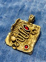 Front view of pendant showing abstract design and cabochons