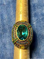 Top view showing oval teal center stone and pavé border