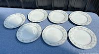 Seven Noritake Colburn dinner plates displayed