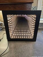 Front view showing infinity mirror light lit and cord