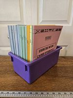 All 34 exercise books standing in purple bin