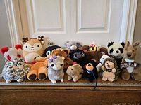All fifteen plush toys lined up against a white door, full lot visible