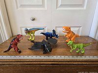 Group shot of six toy figures with ruler for scale