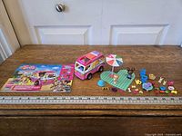 Full set laid out with camper, instruction booklet, baseplate, umbrella, accessories