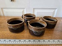 Four stoneware onion soup bowls arranged with ruler for scale