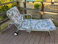 side view of chaise lounge showing aluminum frame, cushion, and wheel