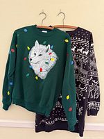 Both sweaters hanging side by side