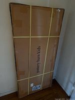 Front view of sealed Pottery Barn Kids shipping box with straps