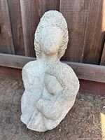 Front view of full stone sculpture showing mother holding child