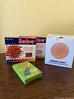 Boxed moon light and two Sculpey polymer clay boxes on table