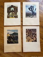 Four mounted color lithographs displayed on floor