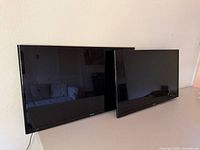 Front view of both Samsung TVs showing size difference