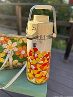 Air-pump dispenser close-up showing poppy design and strap